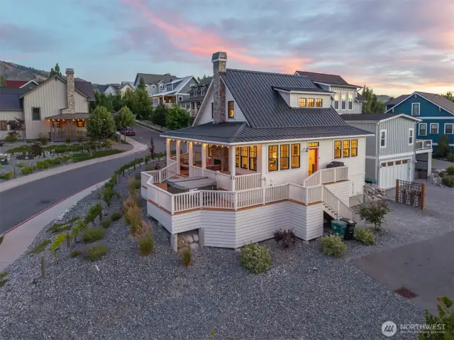 Exterior twilight view of home with wraparound porch.