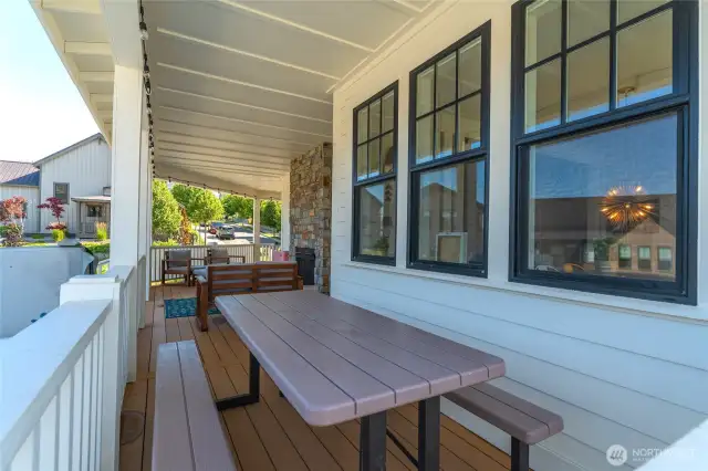 View of classic covered wraparound porch and outdoor eating area.