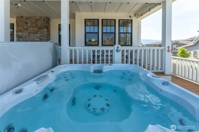 View of private hot tub on classic wraparound porch and outdoor living area.
