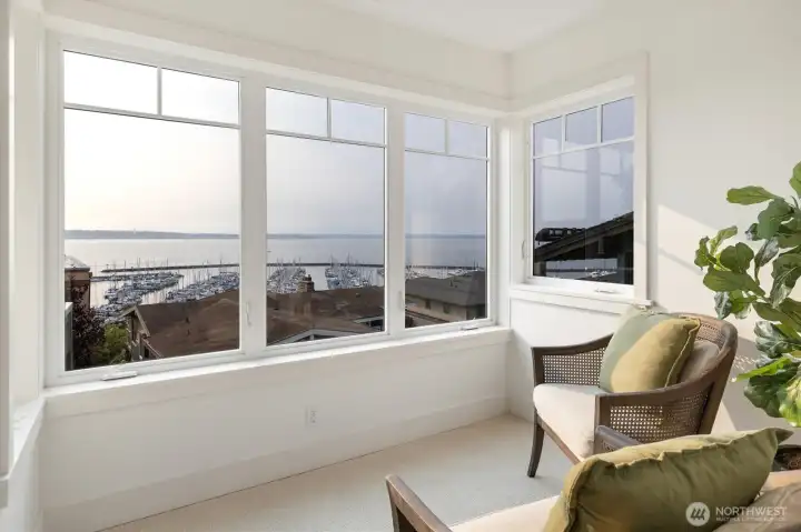 A sunlit sitting area in the primary suite is wrapped in windows, offering panoramic views of Shilshole Bay. It’s the perfect spot to unwind with a book, enjoy morning coffee, or simply take in the ever-changing water view of Shilshole Bay Marina