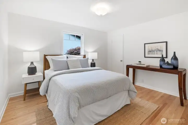 The first of three main floor bedrooms, this inviting space features hardwood floors and fresh finishes, creating a comfortable retreat with convenient access to a full bath.