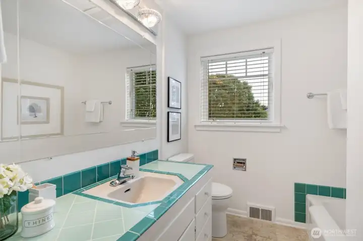 The main floor bath features both a tub and separate shower, with a layout spacious enough to accommodate a dual vanity. Classic tile accents and natural light give the space a fresh, functional feel.