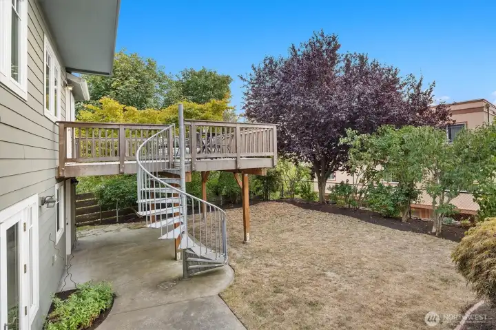 A fully fenced backyard is ideal for play, gardening, pets, and people. A spiral staircase connects to the upper deck, creating easy flow between indoor and outdoor living. The lower level also offers direct access through French doors off the family room or a separate entrance via the laundry room.
