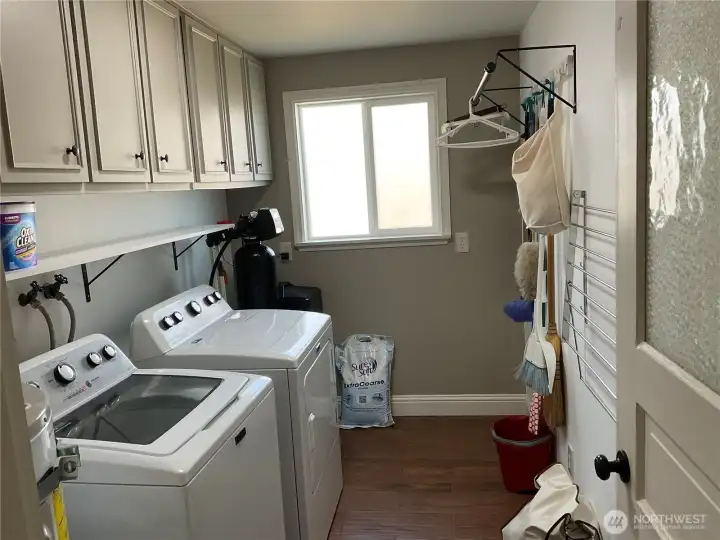 Laundry room featuring water heater & water softener