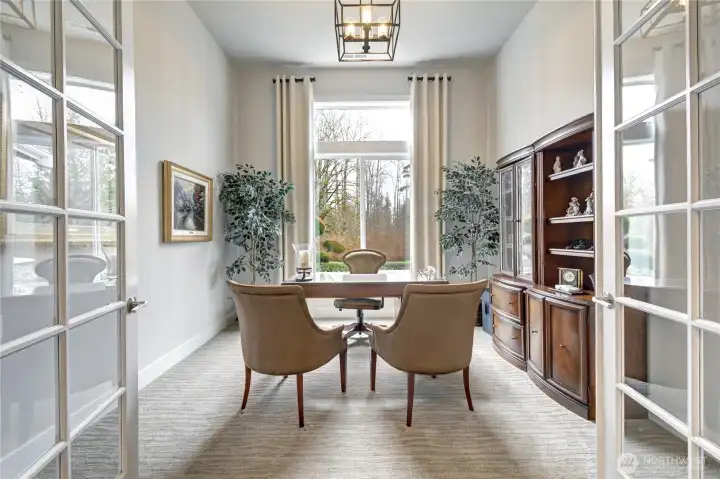 A private den with French doors offers the perfect home office or library.