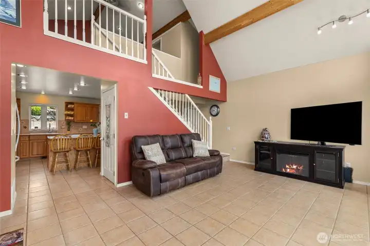 The open-concept living area offers soaring ceilings, cozy gathering spaces, and seamless flow to the kitchen — perfect for relaxed Lake Chelan living.