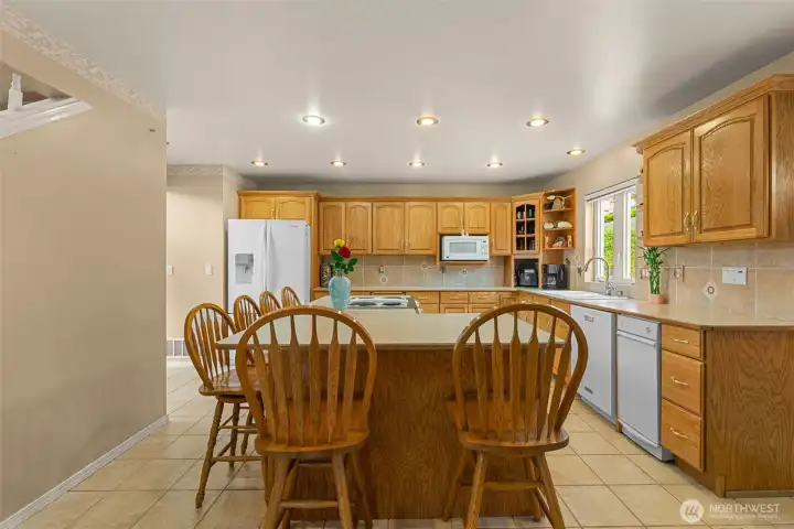 The spacious kitchen features an oversized island with seating for 6+ and comfortably serves as the home’s central gathering and dining space.