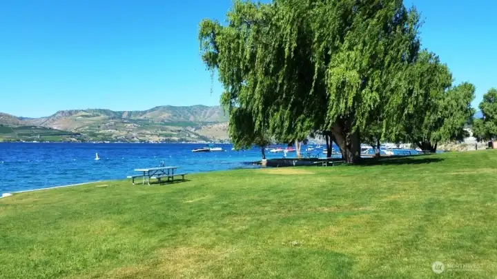 A volleyball net is behind the photographer. There are racks to hold your kayaks or paddleboards, compressed air to blow up your water toys, restrooms, picnic tables, and lots of open space. (Oh, and a pretty nice view, too!)