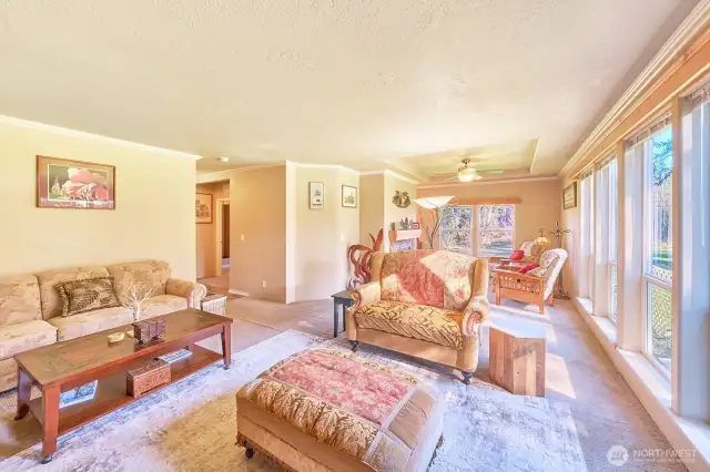 Sunny south end family room with windows looking out to the barn and beyond