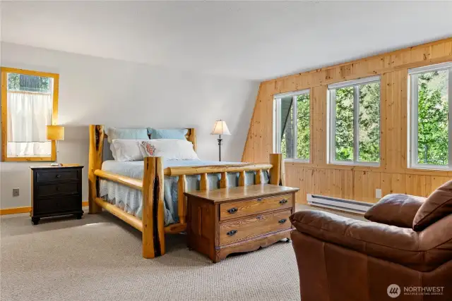 Large Primary with cozy stove & wall of windows overlooks river.