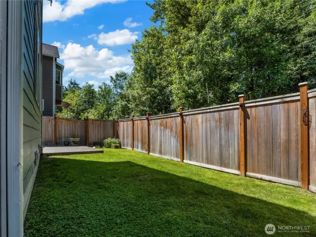 Low maintenance yard with small patch of grass and sprinklers, front & back.