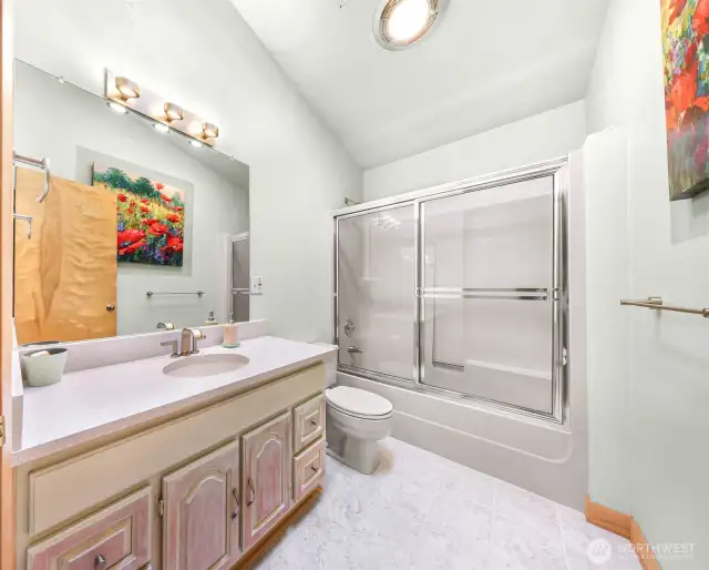 The upstairs hall bath is bright and clean with a vaulted ceiling and full tub-shower combo