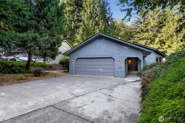 Expansive and level, the wide driveway offers easy access and ample guest parking, bordered by greenery for a secluded feel.