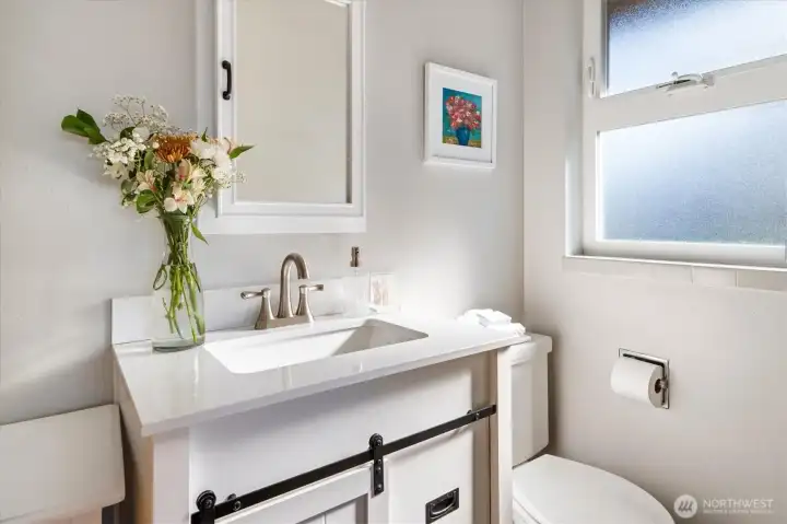 The half bath off the primary bedroom has a fresh look.