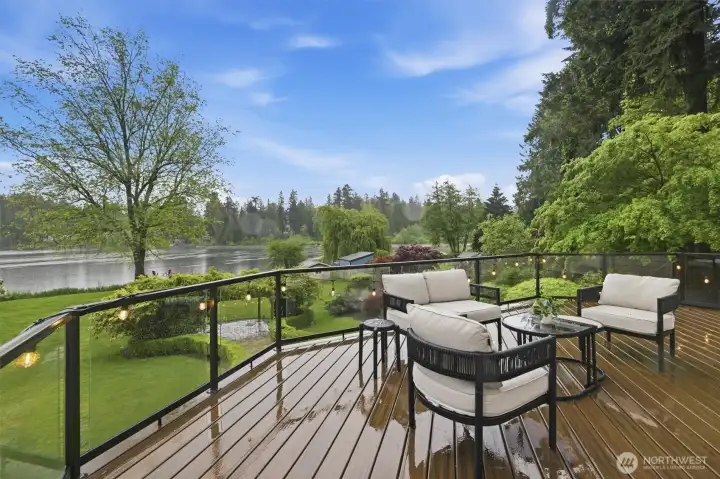 Beautiful new composite Trex deck with glass railing overlooking the grounds and lake.