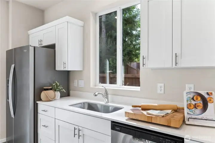 The window over the undermount sink brings in natural light to this kitchen. Soft close cabinet doors throughout this home. Pictures are for representation only colors and options will vary.