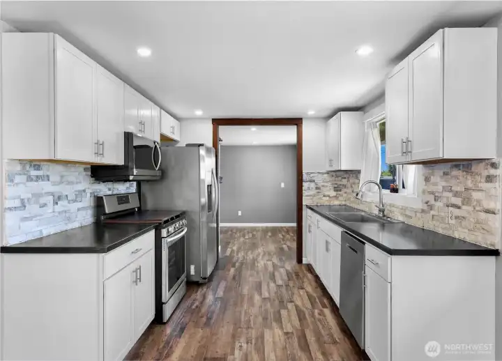 Galley style kitchen looking into the utility/bonus room