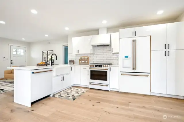 This kitchen invites you to cook away.  Just look at this charming modern kitchen with white marble quartz peninsula, farmhouse sink, Cafe’ white with gold accent handle appliances by GE, ample storage with pantry, and white subway tile full backsplash.