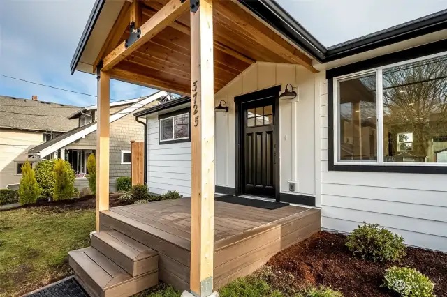 It's so nice to have a large covered space as you greet guests.  The greenery surrounding the front door is lovely contrasting with the handsome black front door.