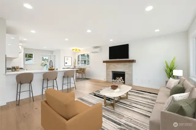 Inviting entry boasts a new gas fireplace insert and wide planked wood floors underfoot in the spacious living room that opens to the dining space and charming modern kitchen.