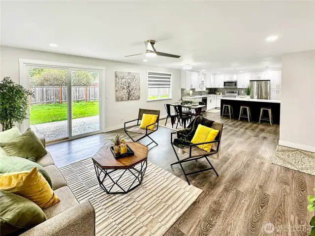 Looking from great room towards dining and kitchen.  Lots of light and ceiling fan.  Slider leads to rear yard and patio.