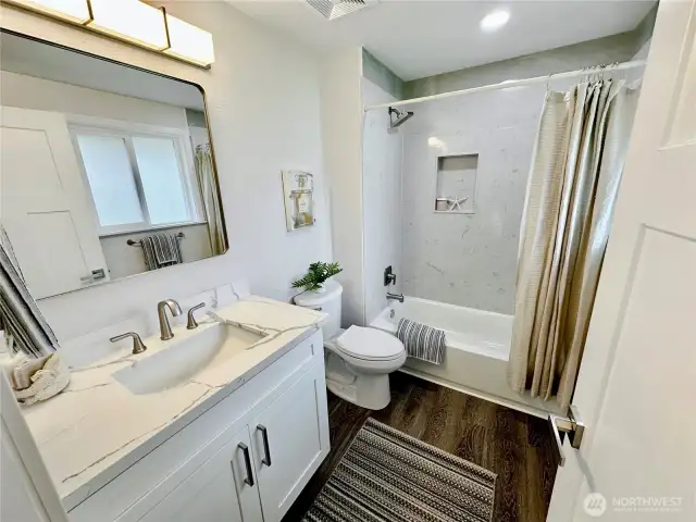 Lovely primary bath, laminate flooring, quartz  tub/shower surround.