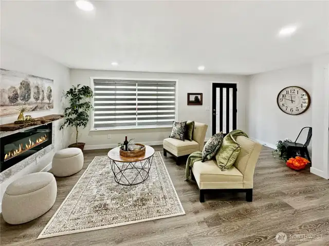 View of living room from kitchen showing stylish front door and luxury blinds.