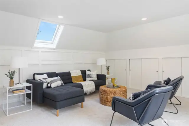 Spacious upstairs bonus/recreation room with skylight and built ins. Located above the garage.