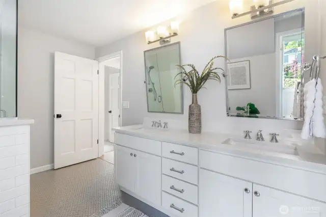 Remodeled upstairs bathroom with quartz countertops and glass shower.