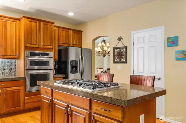 The kitchen has tall ceilings, recessed lighting, a large island and a walk in pantry.  The formal dining room can also be seen to the right of the frig.
