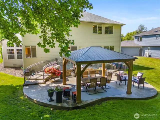 The back of the home has gracefully curved wrought iron railings that lead to a covered outdoor patio. It is adjacent to a green belt offering privacy,  peace and a sense of natural beauty.