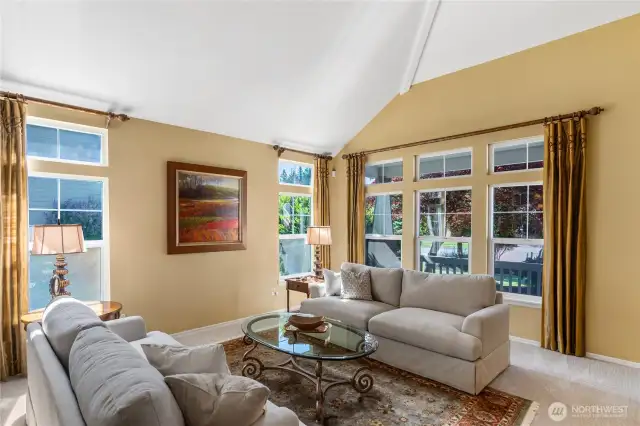 Light spills into the living room from the large windows and the space feels voluminous with the vaulted ceilings.