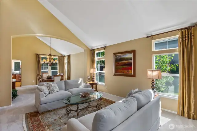 Despite its grandeur, the home feels warm and inviting. The living room opens into the dining area and allows for glimpses of the kitchen beyond.