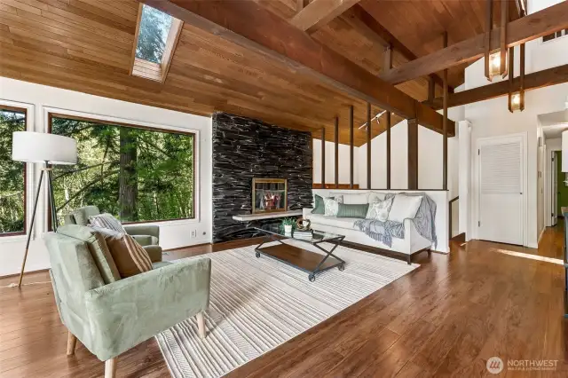 Main floor living room with vaulted ceilings and exposed structural beams.