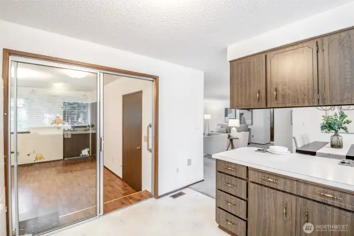 The family room off the kitchen has the clever design of a sliding glass door for a noise barrier