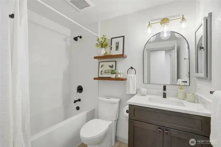 Second floor main bathroom with soaking bathtub and custom tile surround and niche