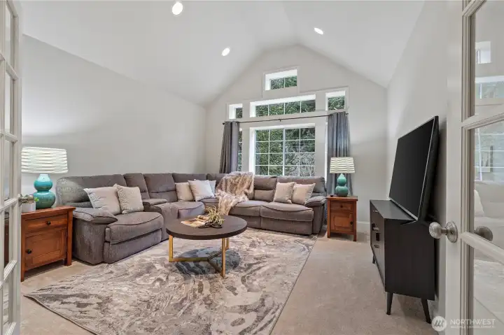 The HUGE bonus room boasts a vaulted ceiling, abundant lighting, and elegant glass French doors—ideal for a media room, home office, or flexible living space.