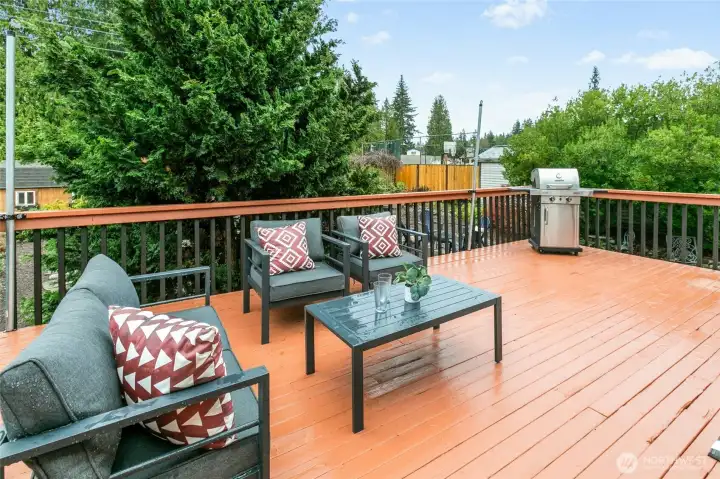 Just outside - an awesome deck perfect for outdoor entertaining or eating al fresco. Barbecue is in great shape and can stay with the house!