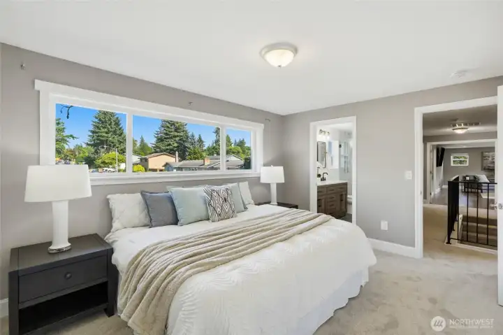 Generous upper-level bedroom with abundant natural light and direct access to the adjacent bathroom.