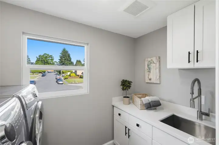 Spacious utility room with built-in cabinetry, utility sink, and plenty of storage.