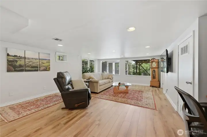 Family room on lower level with newer luxury vinyl plank flooring. Get ready for game or movie nights Family room on lower level with newer luxury vinyl plank flooring. Get ready for game or movie nights