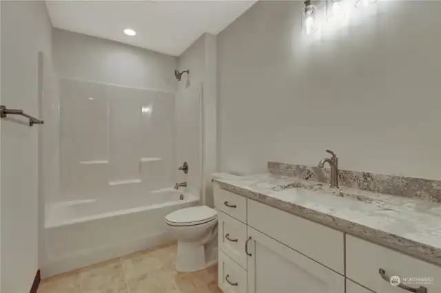 Guest bathroom/ shared bathroom, directly from the living room makes for easy access and simple clean cabinets to match the rest of the home.