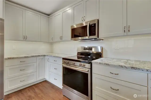 Top quality granite countertops, upgraded new appliances, and sleek white cabinets.
