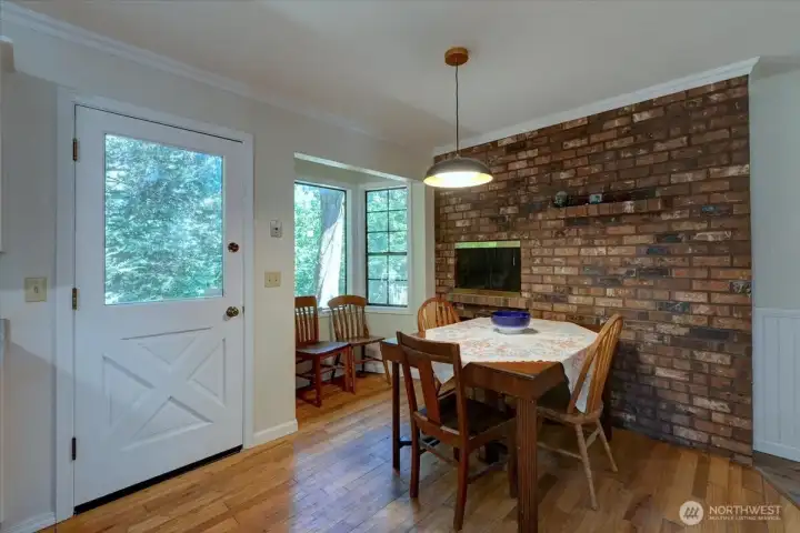 Another look at the kitchen fireplace, breakfast nook and door to back yard.