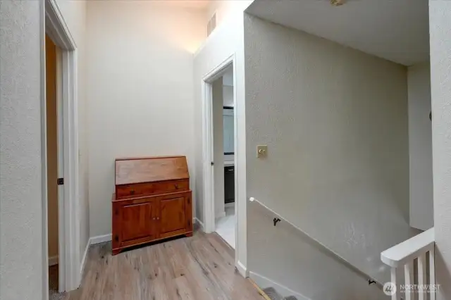 Just to the top of the stairs, door at left leads to primary bedroom suite. Door at right is 2nd floor bath. New LVP flooring on hallways here.