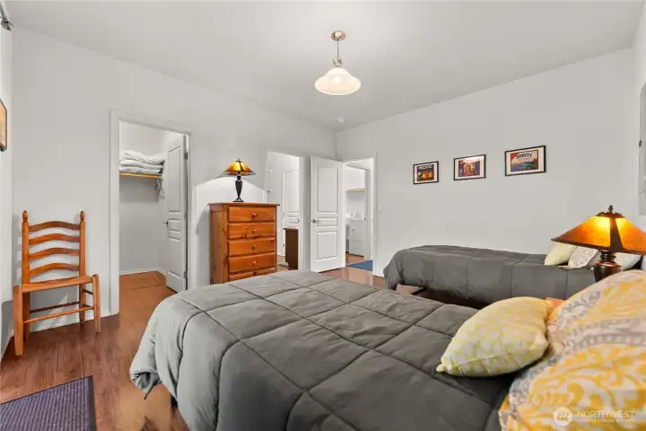 Fully furnished bedroom with twin beds, a dresser, and cozy lighting. Includes a spacious closet and convenient access to the laundry room.