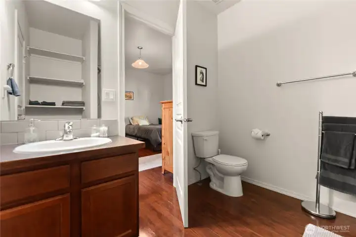 Modern bathroom with ample storage, a sleek vanity, and a shower/tub combination. Convenient access to the adjacent bedroom.