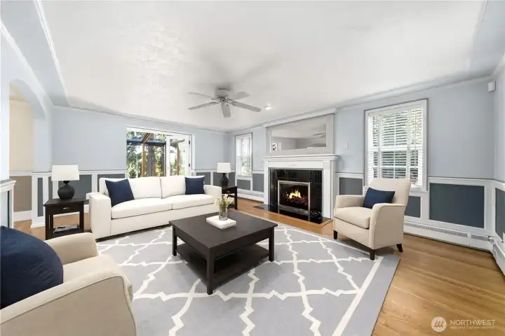 Gleaming hardwoods greet you in the main floor living room, along with a gas fireplace and wainscoting, that opens to the sunroom.