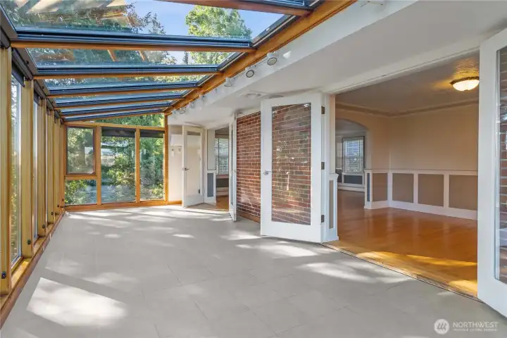 At the far end of the solarium, you can see another mini-split for A/C during the warm summer months. The dining room is shown through the french doors in this photo.