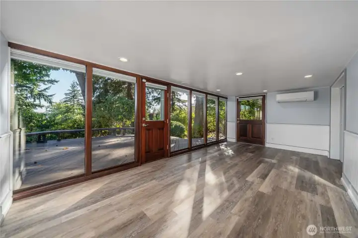 Another view of the flex space downstairs with a wall of windows to the beautifully private yard. There's a ductless mini-split on the main floor and also down here for A/C.